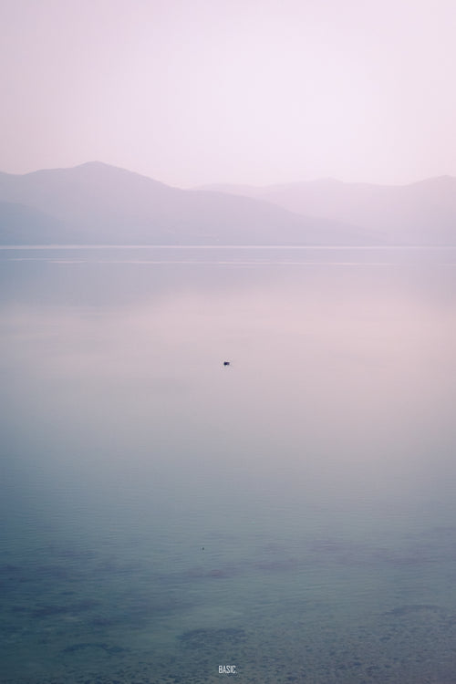 Hazy landscape with mountains and a small island in the distance.