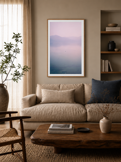 Cozy living room with a beige sofa, wooden coffee table, and framed artwork on the wall.