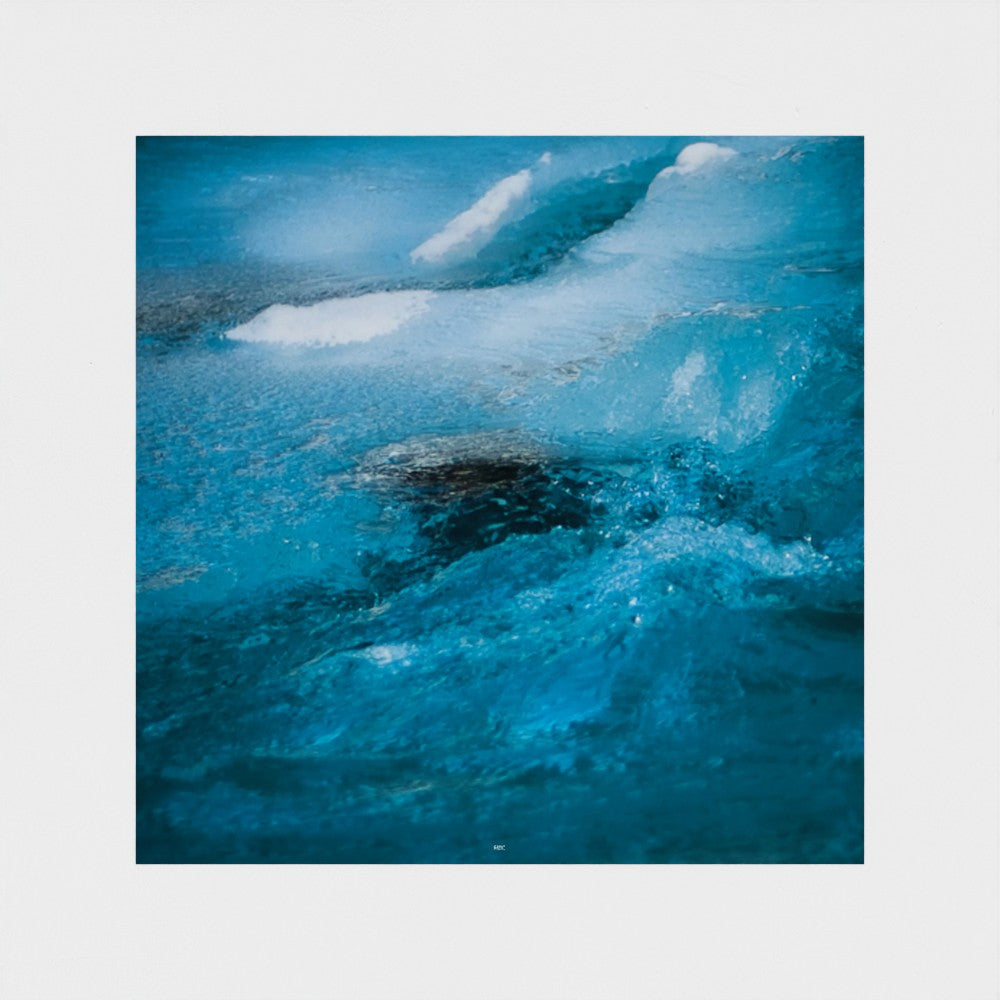 Abstract photographic print of a blue ocean wave with white foam, centered on a light gray background.