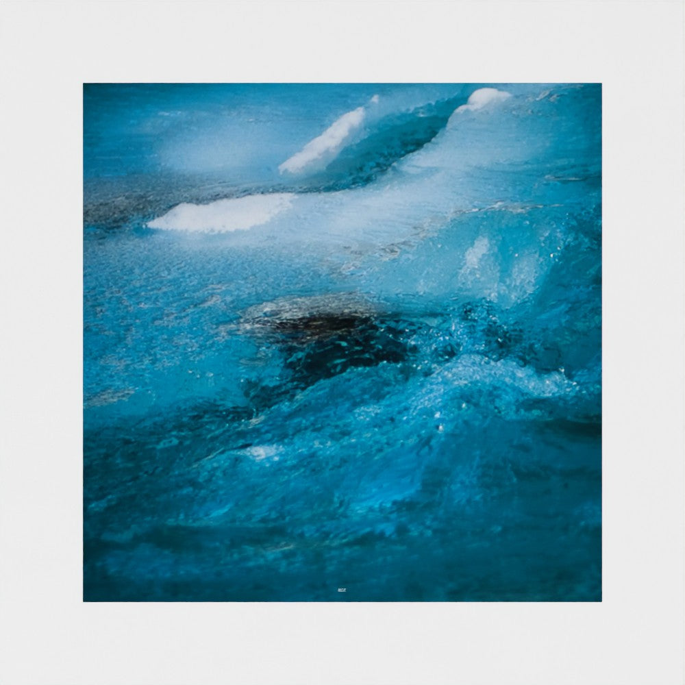 A square photographic art print depicting a close-up of a blue ocean wave with white foam, centered on a light gray background.