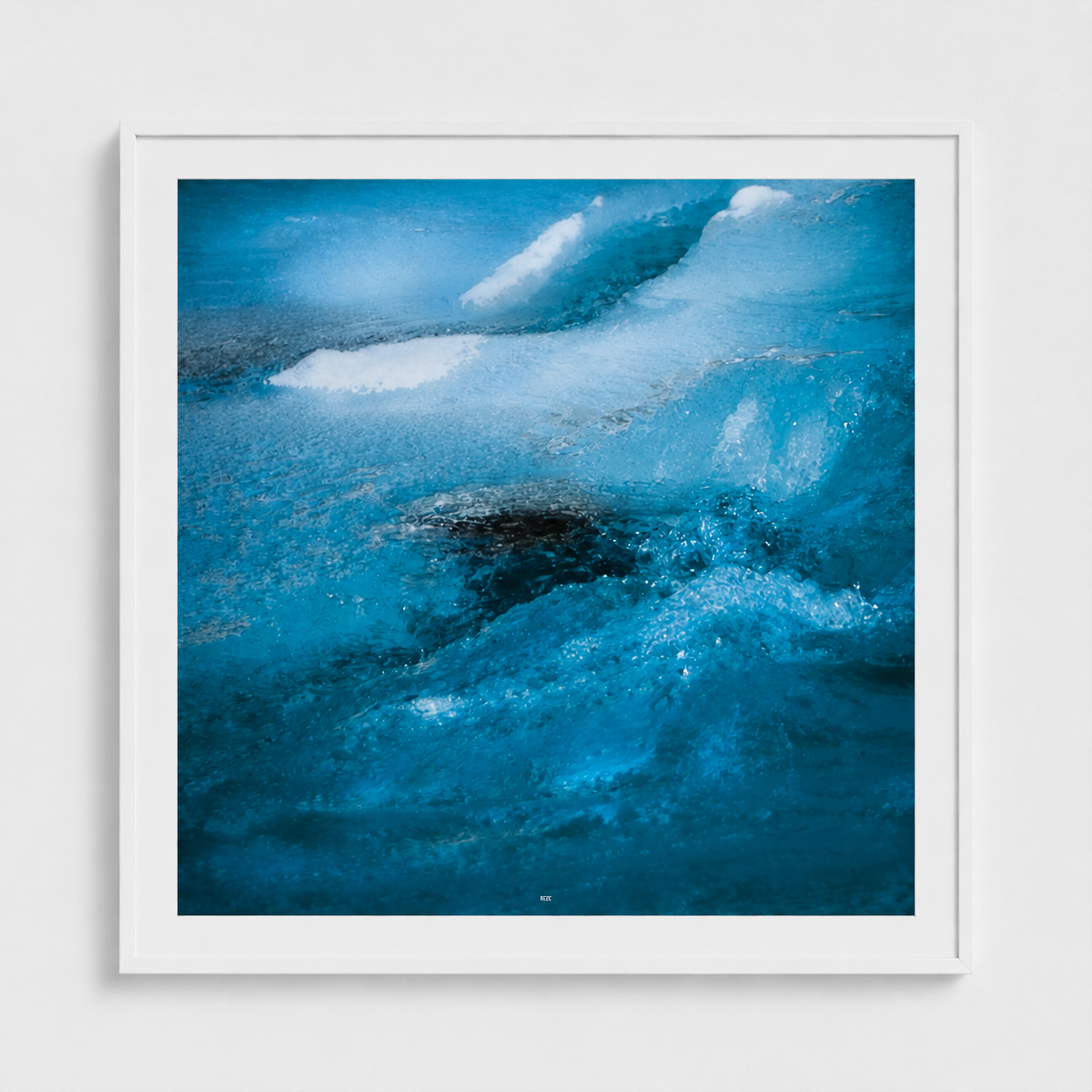 A framed abstract art print depicting swirling blue and white water-like textures, presented in a white frame against a light gray wall.