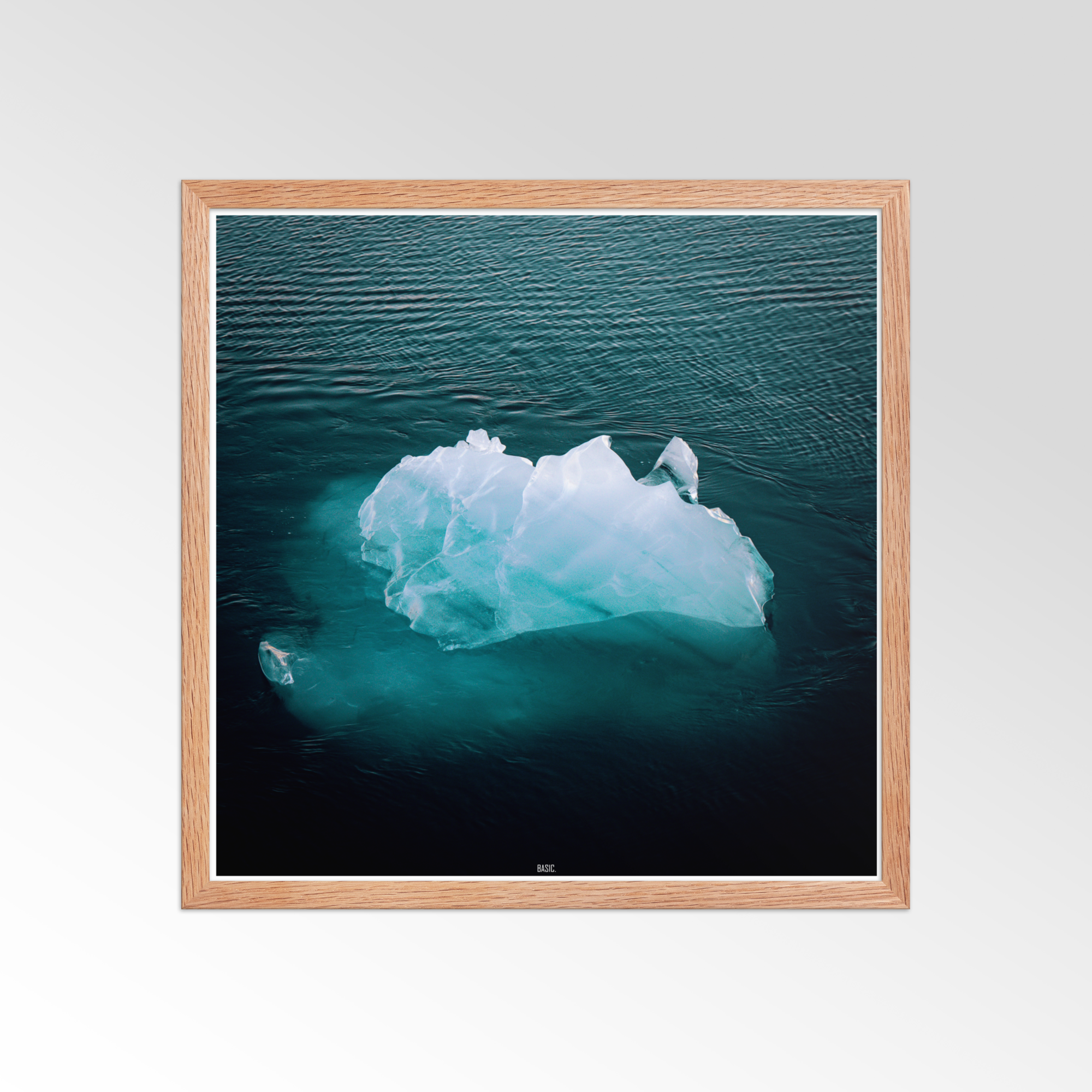 Framed photograph of an iceberg in the ocean on a white wall