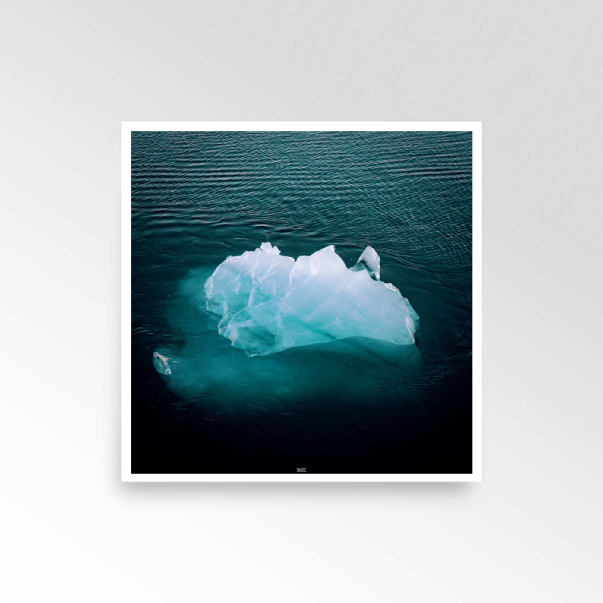 Framed photograph of an iceberg floating in water on a white background