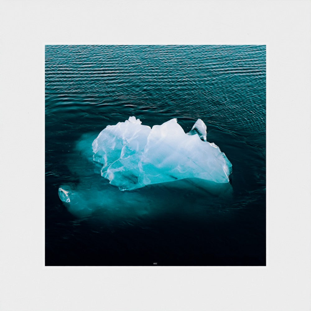 Iceberg floating in the ocean with a white border