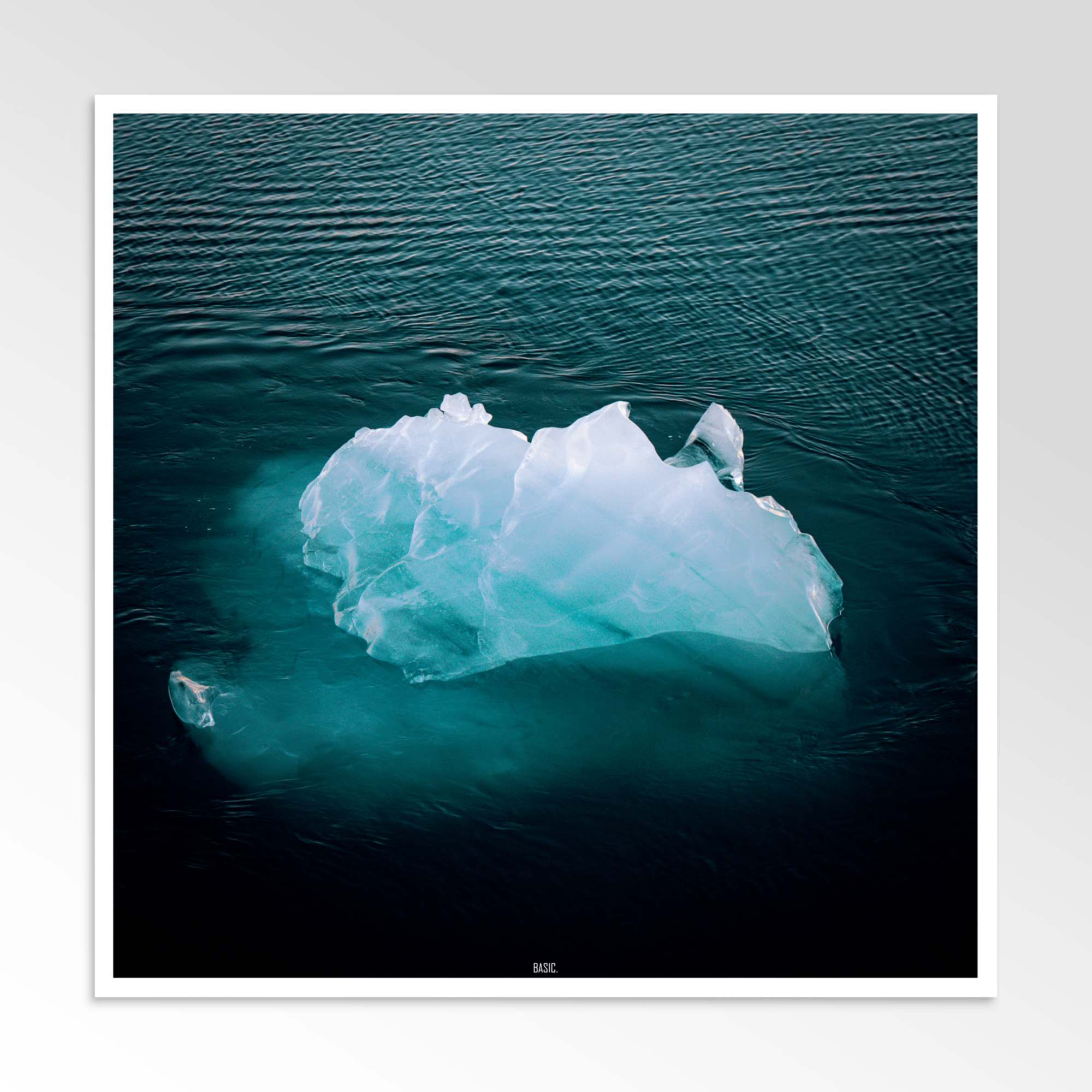 Iceberg floating in dark blue water with a white border
