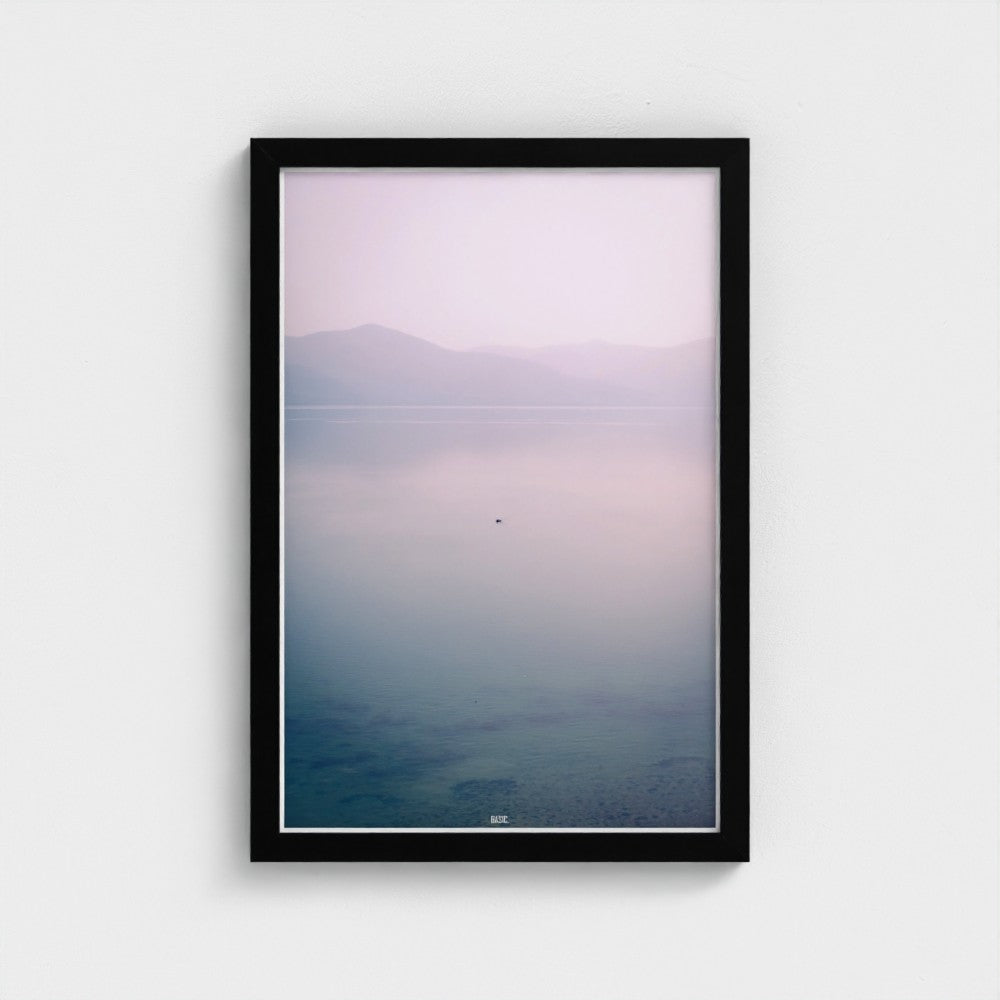 Framed artwork with a gradient landscape from purple to blue on a white wall