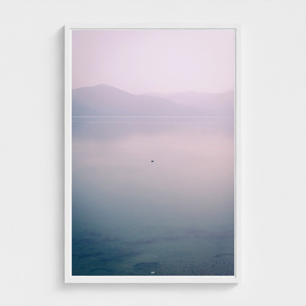 Framed artwork of a landscape with a gradient sky over water