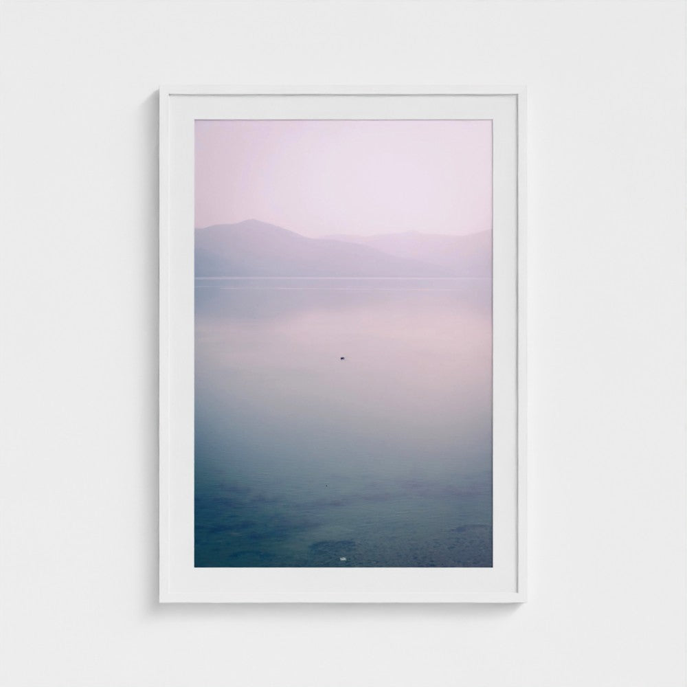 Framed artwork of a landscape with a gradient sky and water.