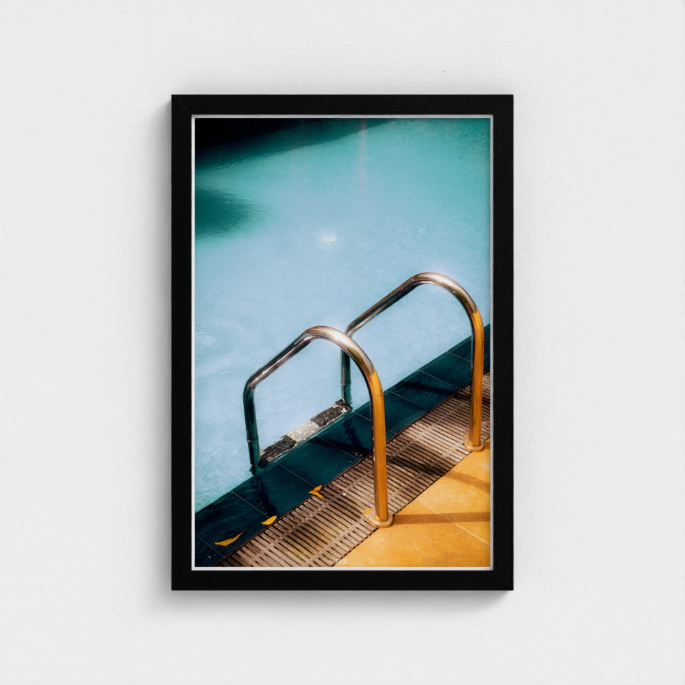 Framed photograph of a pool with a metal ladder on a white background