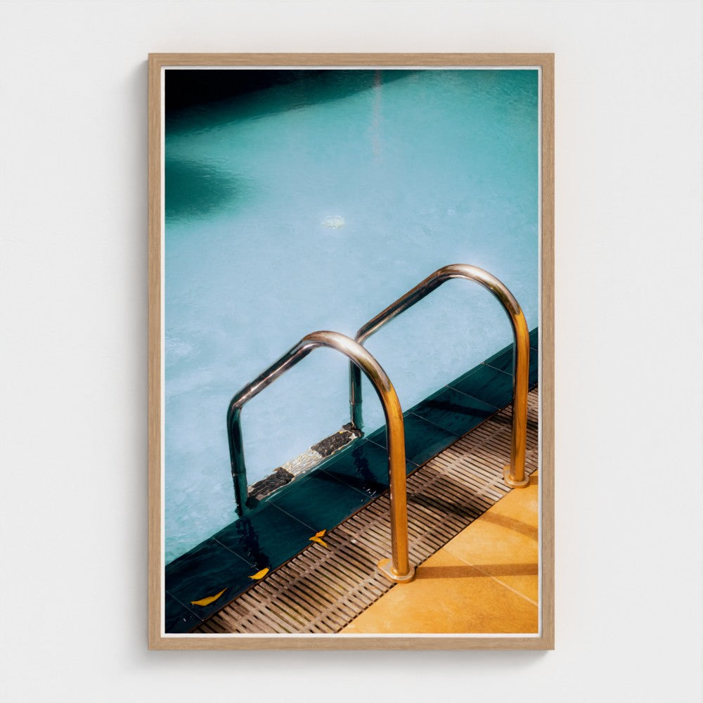 Framed photograph of a pool ladder with blue water and wooden deck.