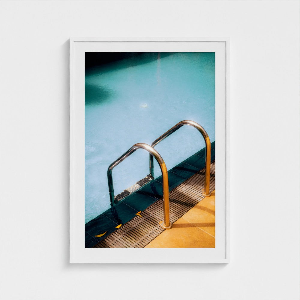 Framed photograph of a pool with a metal ladder on a white background
