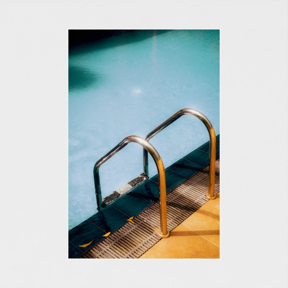 Metal ladder leading into a pool with clear blue water
