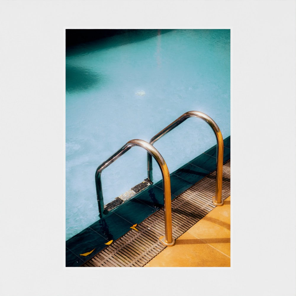 Metal ladder leading into a pool with clear blue water
