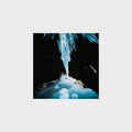 A square art print depicting a dramatic ice cave scene with a glowing blue icicle hanging from a dark cave ceiling, shown against a light gray background.
