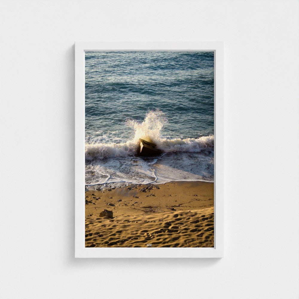 Framed photograph of a beach scene with waves crashing onto the shore.