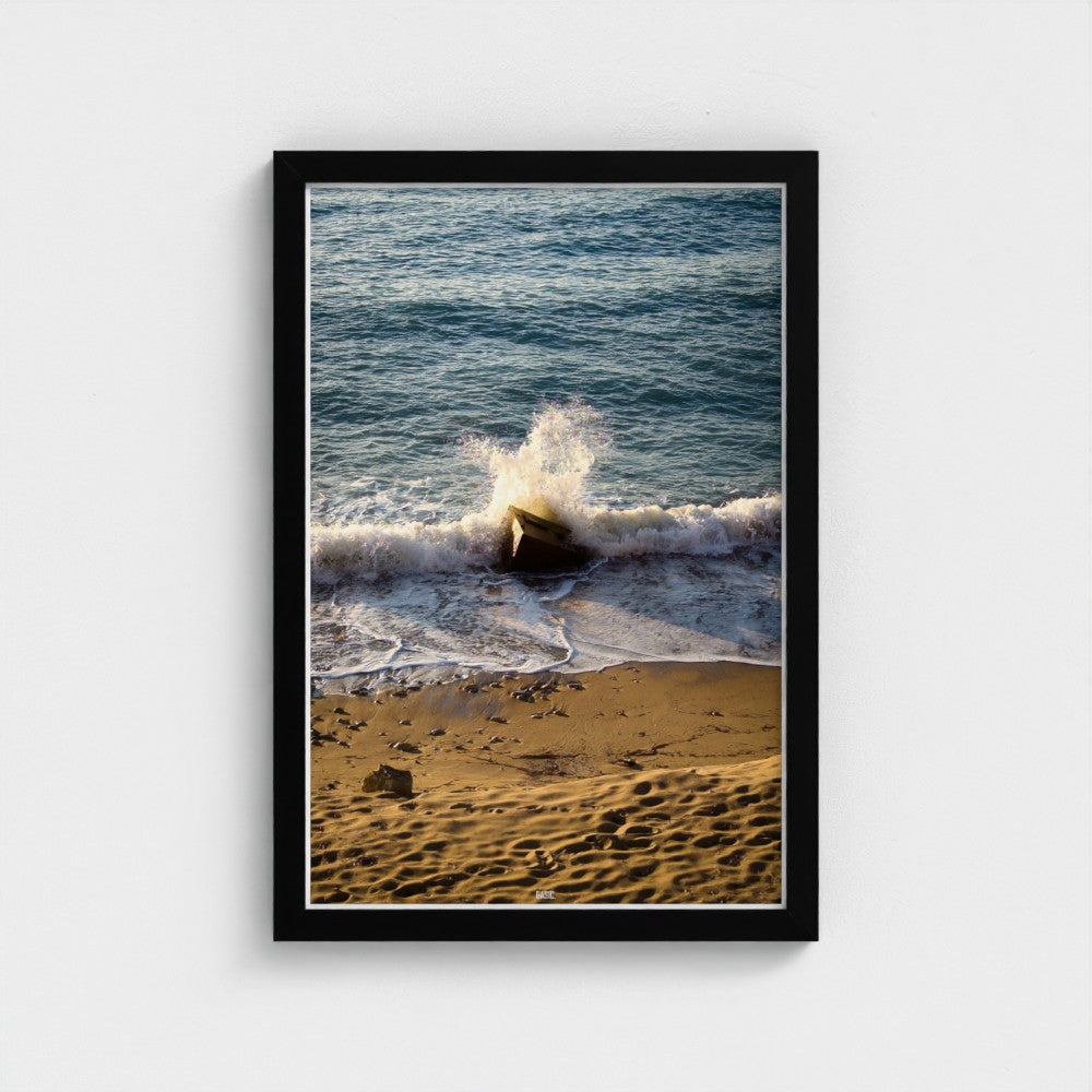 Framed photograph of a beach scene with waves crashing onto the shore.