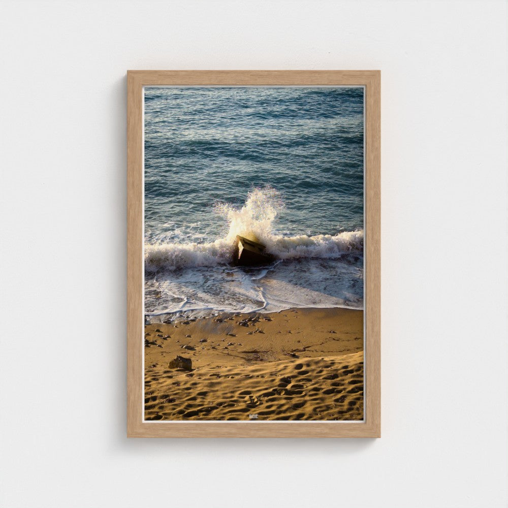 Framed photograph of a beach scene with waves crashing onto the shore.