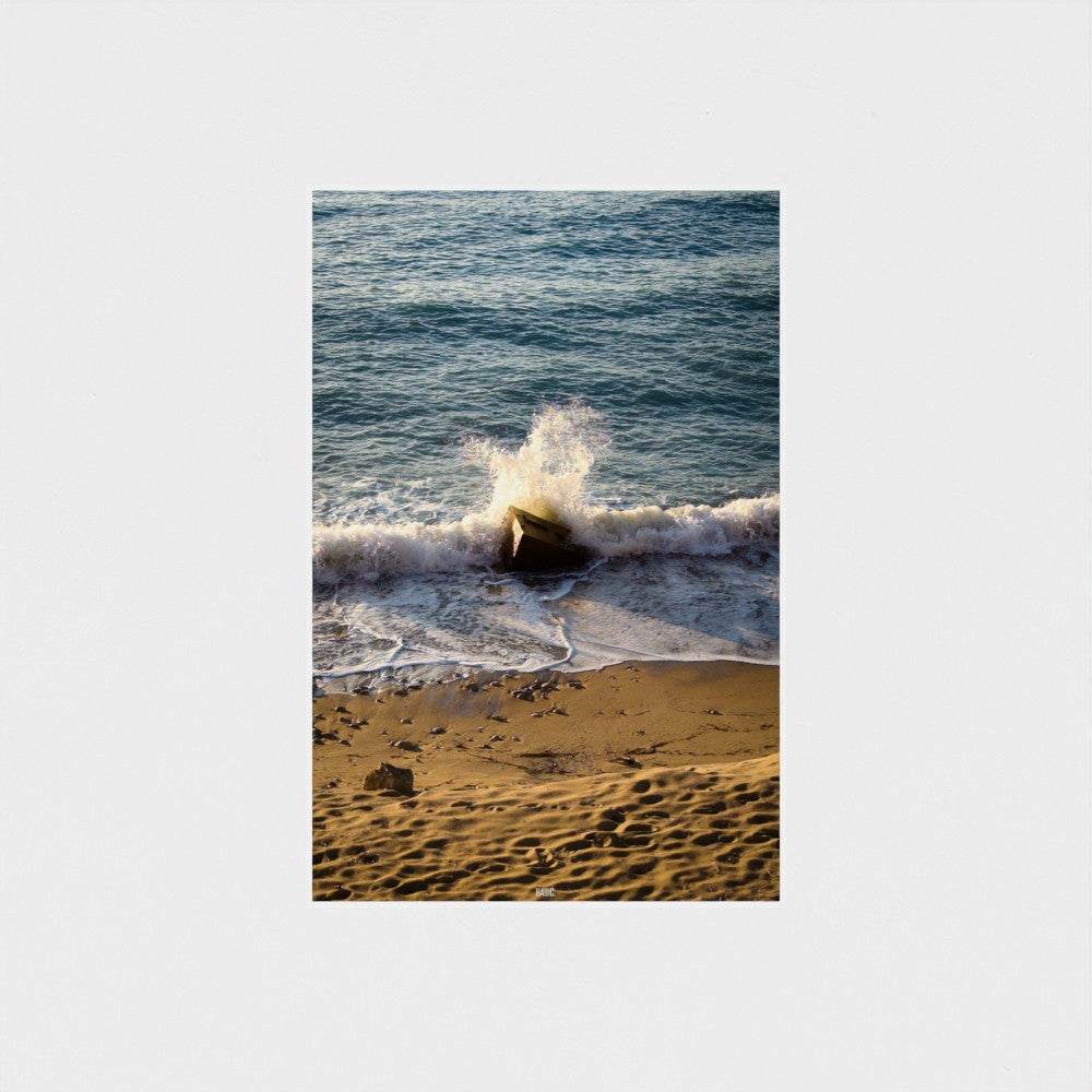 Wave crashing onto a beach with sand and water.