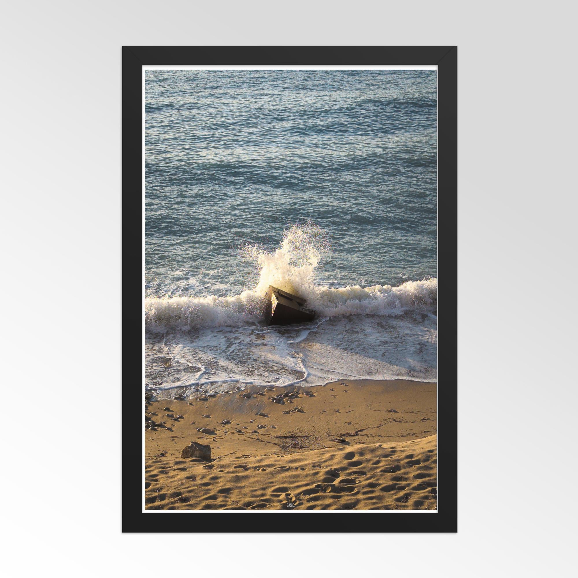 Framed photograph of waves crashing on a beach with a black border.