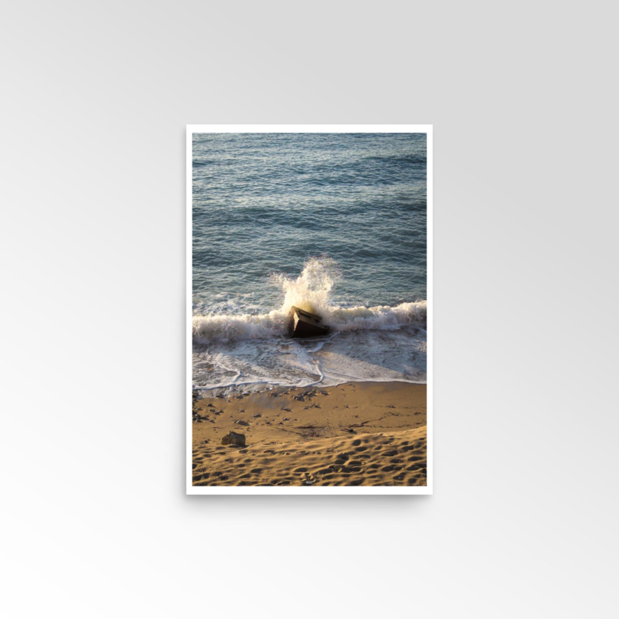 Framed photograph of a wave crashing on a beach with a white border.