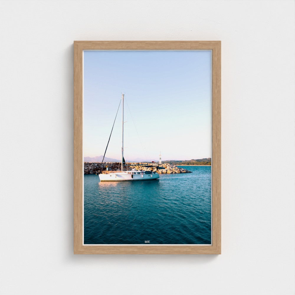 Framed photograph of a sailboat on water with a wooden frame.