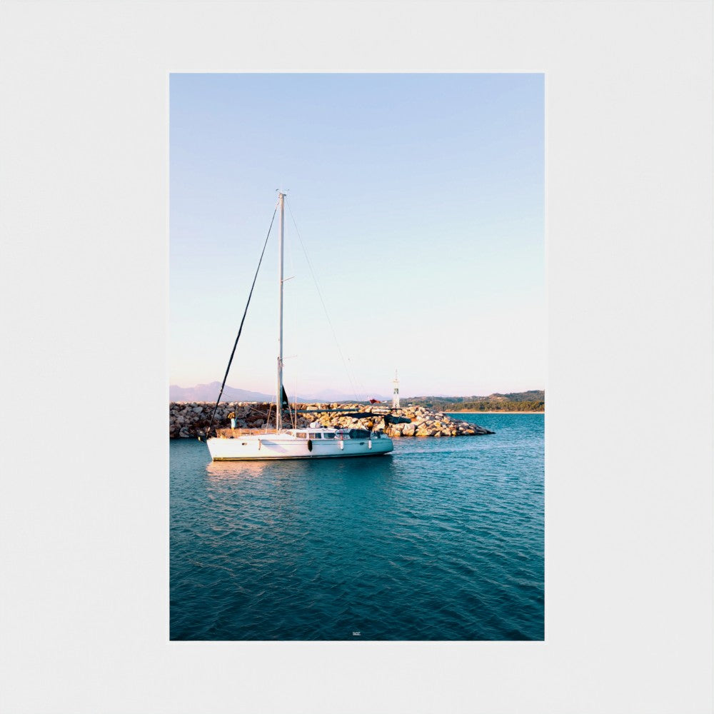 Sailing boat on a clear blue sea with a white border