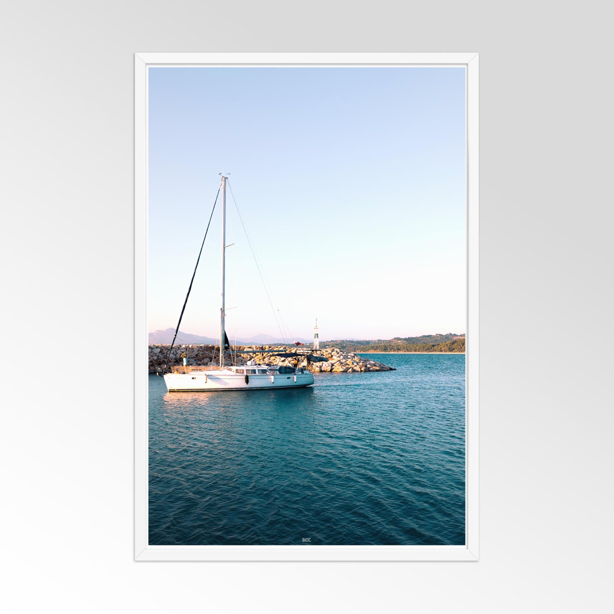 Framed photograph of a sailboat on calm water with a white frame.