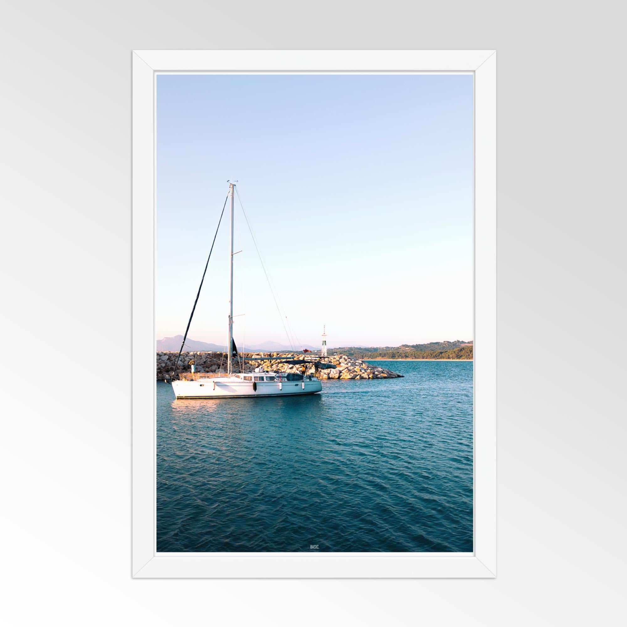 Framed photograph of a sailboat on calm water with a white frame.